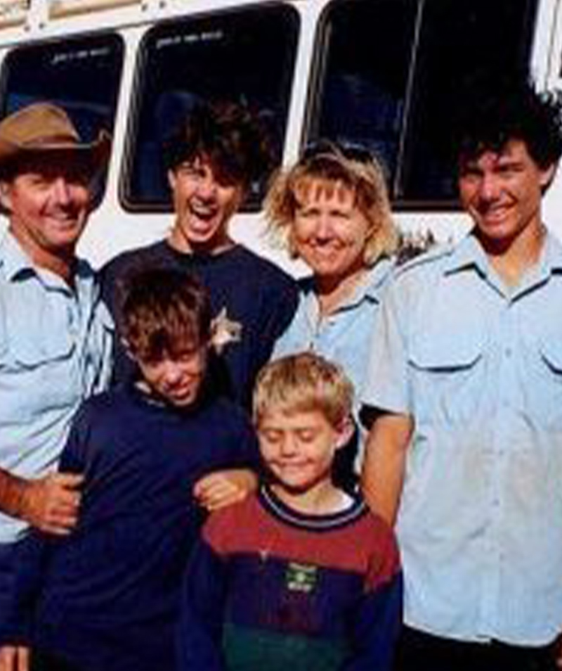 Neil and Coralie McLeod with their four sons beside a tour bus in Exmouth
