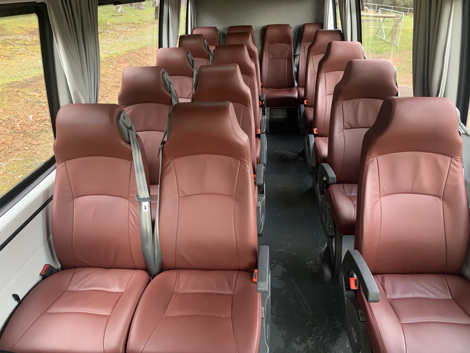 Looking down the centre aisle of the Iveco Daily, burgundy leather seats in rows either side