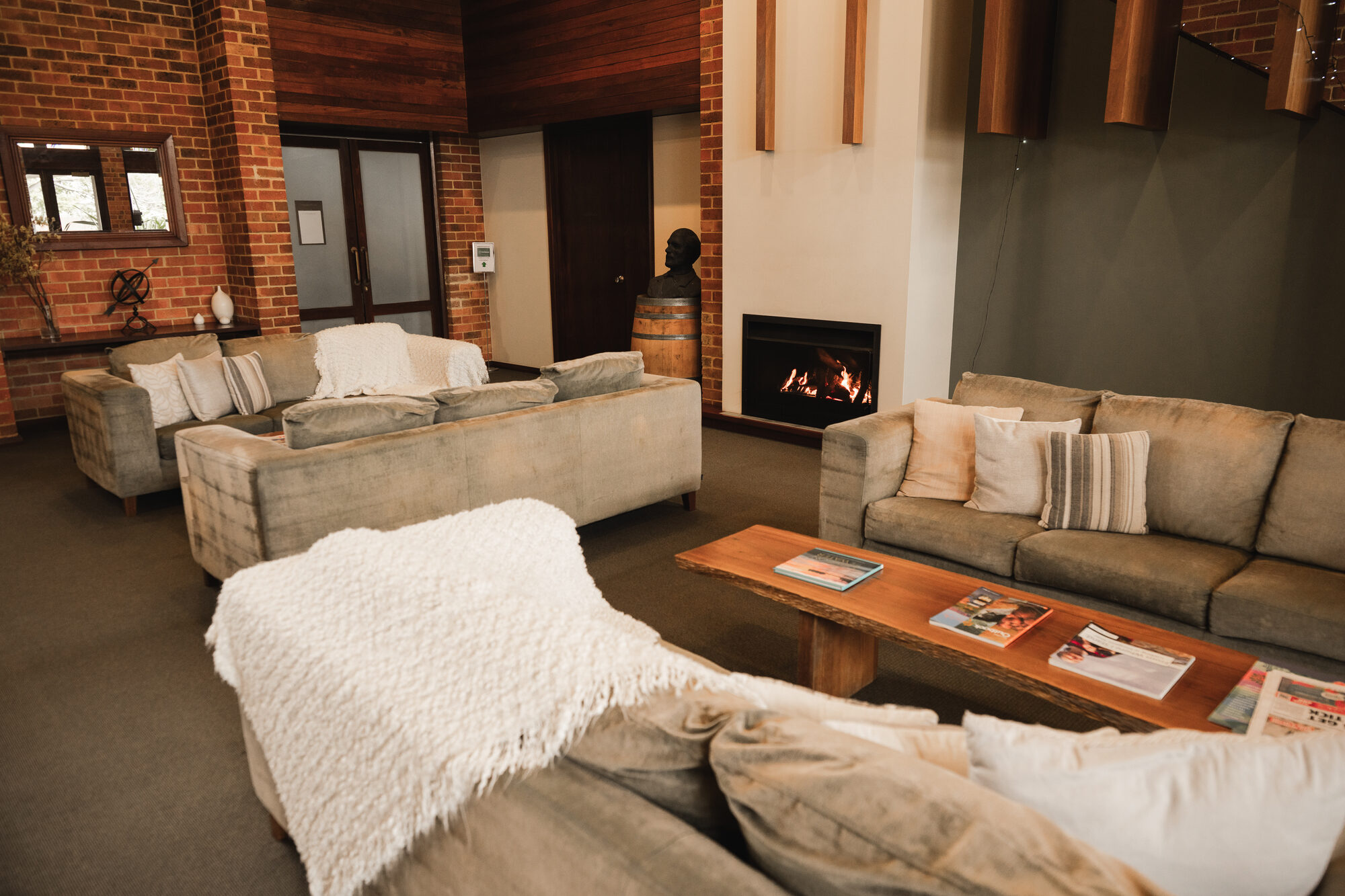 The guest lounge: deep sofas and sheepskin throws around a lit fireplace