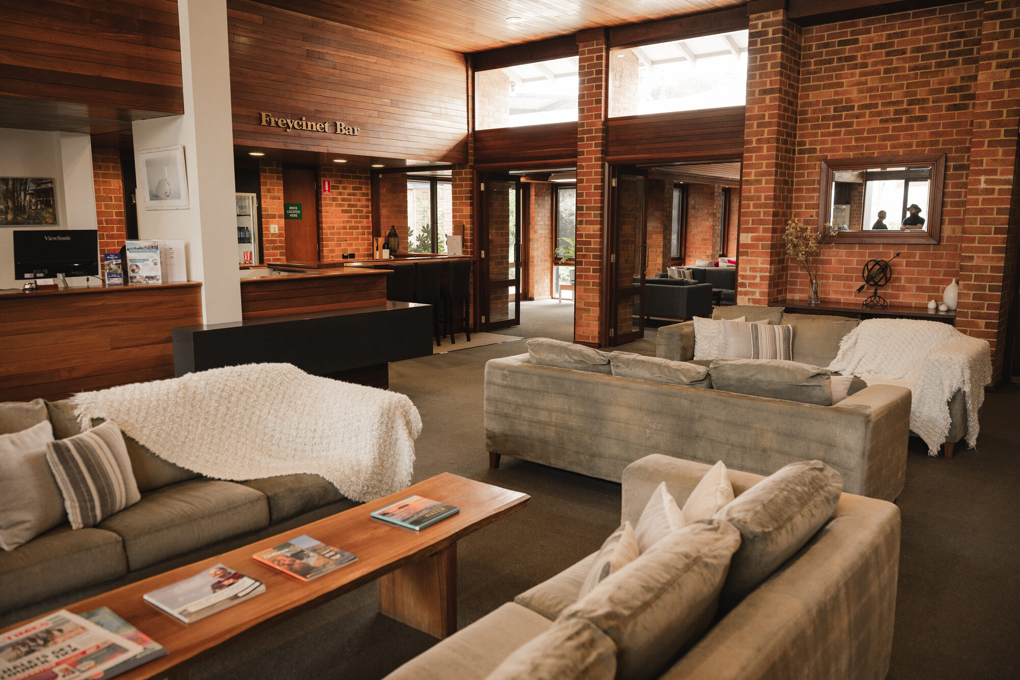 Reception and the Freycinet Bar, brick and jarrah under a raked timber ceiling