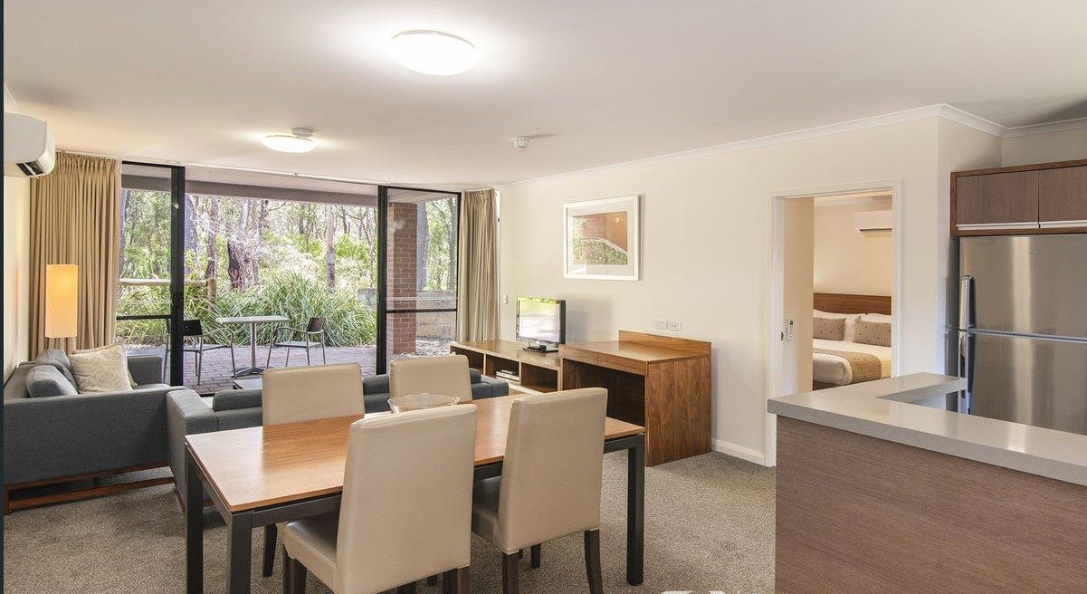 Open-plan living and dining with a kitchenette, and the bedroom through the door