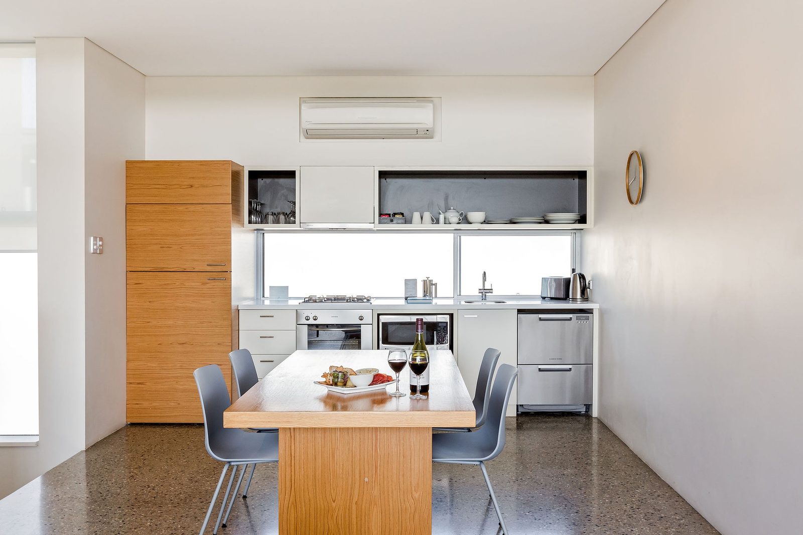 Full kitchen with gas cooktop, oven and dishwasher, and a dining table for four