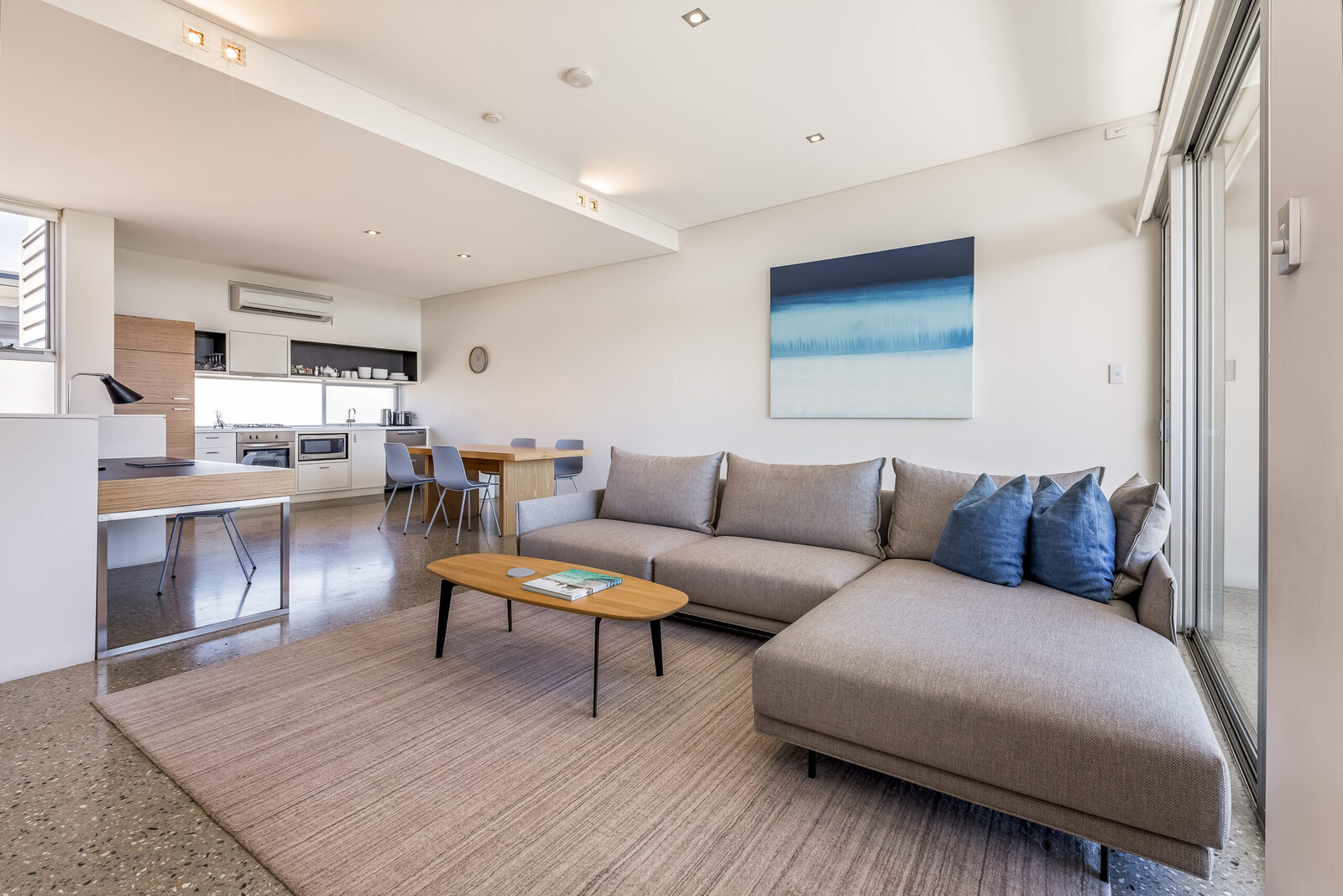 The whole upstairs floor: sofa and rug in front, kitchen and dining table behind