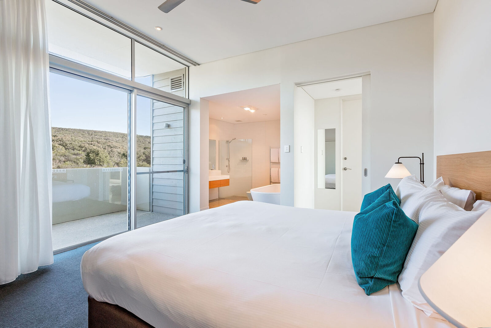The master bedroom opening to its own balcony, the ensuite bath through the door