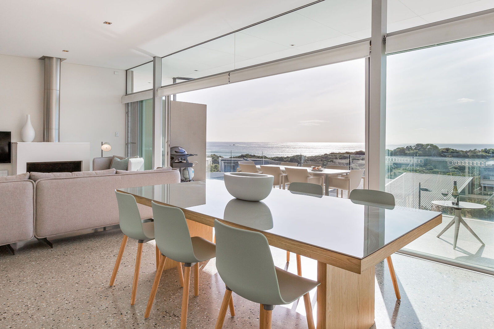 The dining table for six between the fireplace and the open balcony doors
