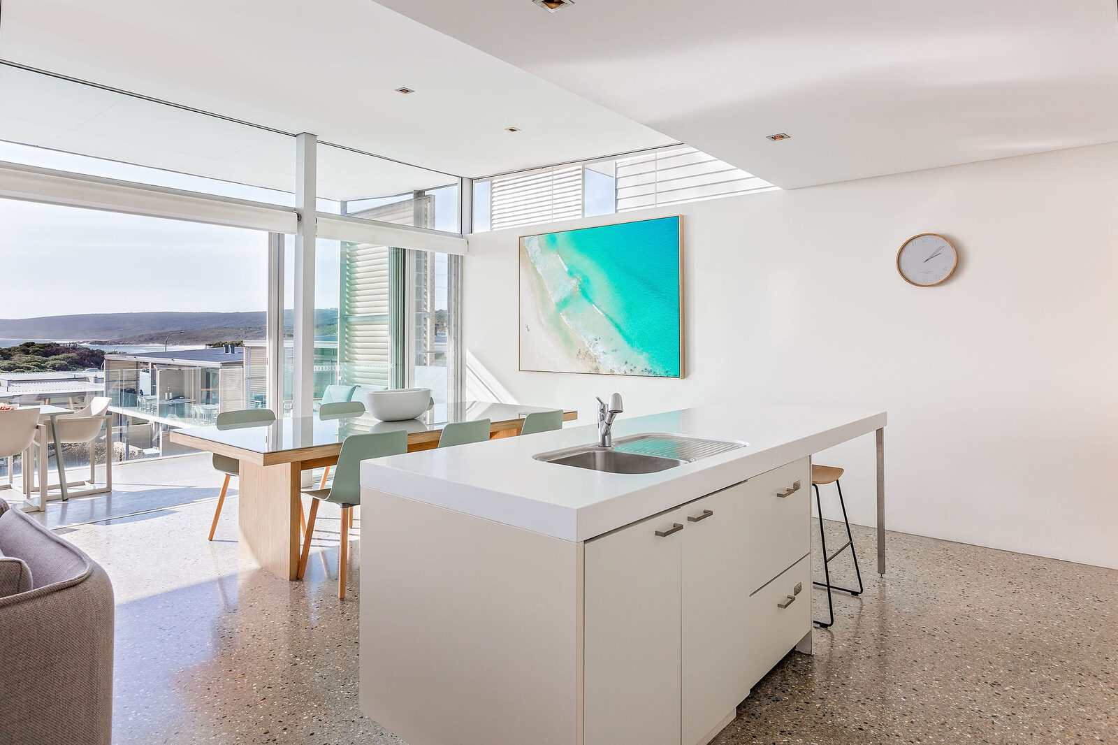The kitchen island looking out past the dining table to the water
