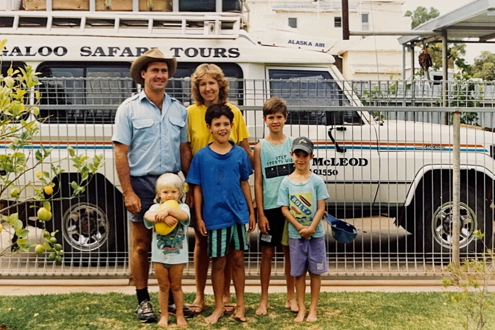 Neil and Coralie McLeod with their four sons beside a tour bus in Exmouth